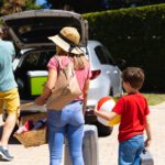 Happy family putting their luggage in their car on sunny day. family trip and vacation concept, unaltered.